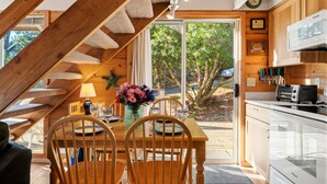A wooden interior with a dining area, kitchen, and a staircase. - Blue Pearl MCA#278-Perfect couples retreat. Dogs welcome, 4 blocks to beach (Manzanita)