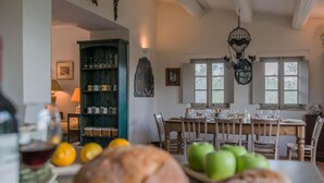 A dining area with a table set for four, surrounded by wooden chairs. A green cabinet with glassware is visible in the background. - Casa Antonio - Private villa, 4 bedrooms, pool, A/C, wifi, pets, Marche (Mogliano)