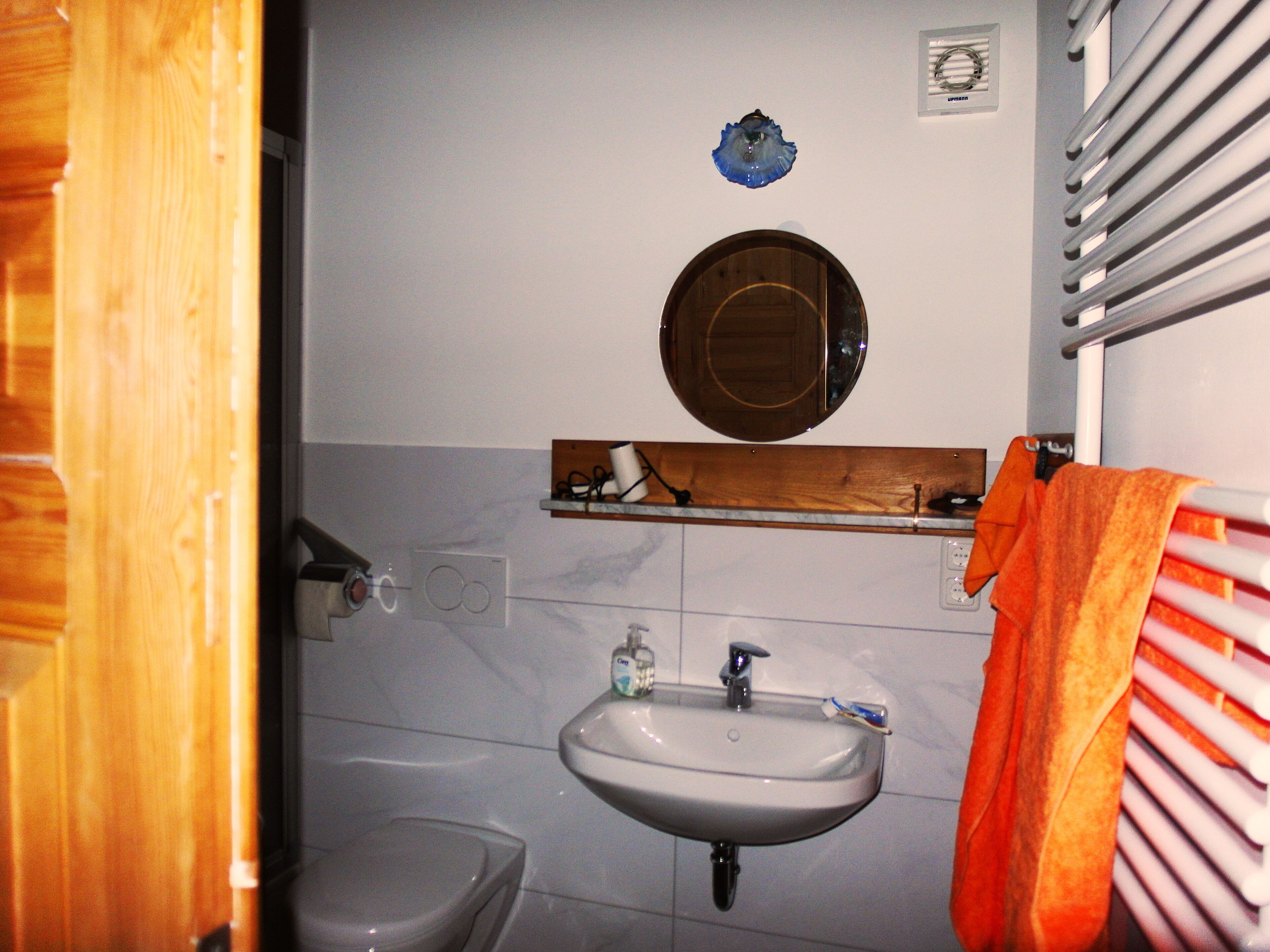 Un baño con inodoro, lavabo y espejo.