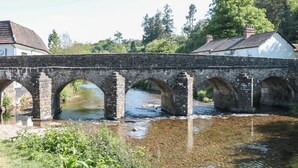 A stone bridge over a river with a house on one side. - The Snug (Dulverton)