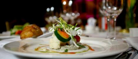 Un plato de postre con una variedad de ingredientes coloridos, como una porción de pastel, una bola de helado y verduras frescas.
