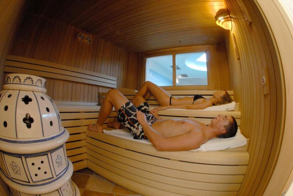 A sauna with wooden benches and a decorative ceramic piece.