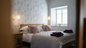 A bedroom with a bed, bedside tables, and a window with blinds. - Host Stay No 2 Lavender Cottage (Belford)