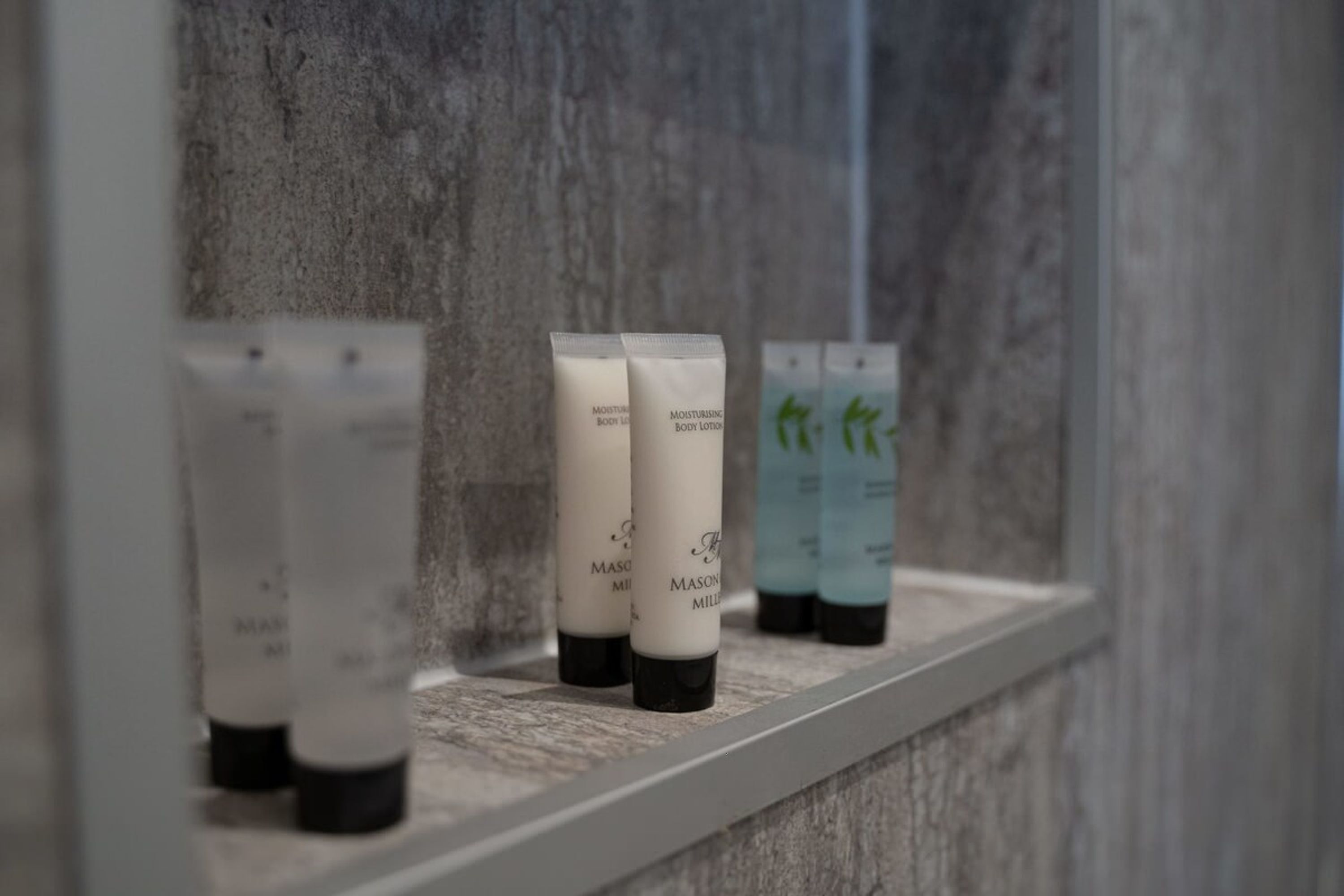 A shelf with several bottles of body lotion.