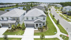 A residential area with modern houses, a well-maintained lawn, and a road. - Bellavida Resorts 9 Themed bd Private Pool Disney (Kissimmee)