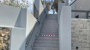 A staircase with a stone wall on one side and a modern building on the other. - Lusol Seafront Villa Ii-free Heated Pool 100m Sea (Chania)