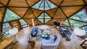 A spacious interior with a high ceiling, large windows, a cozy seating area, and a wooden floor. - The Legendary Snow Globe of Estes Park (Estes Park)