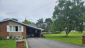 A residential house with a garage, a covered porch, and a lawn.