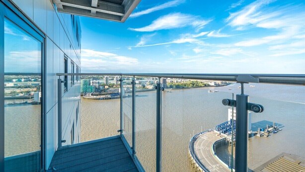 Un point de vue élevé surplombant une rivière, avec un pont et une zone d’amarrage.