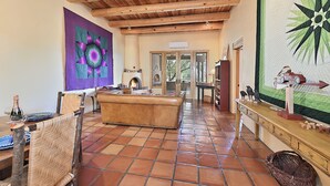 A spacious living area with a large couch, wooden ceiling beams, and a tiled floor. - 2 Bedroom, 2 Bathroom Luxury Townhome; 0.3 miles to Canyon Rd;  AC; Lovely Views (Santa Fe)