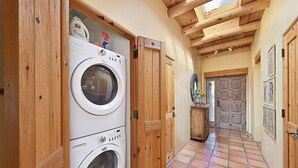 A laundry room with stacked washers and dryers, wooden doors, and a tiled floor. - 2 Bedroom, 2 Bathroom Luxury Townhome; 0.3 miles to Canyon Rd;  AC; Lovely Views (Santa Fe)