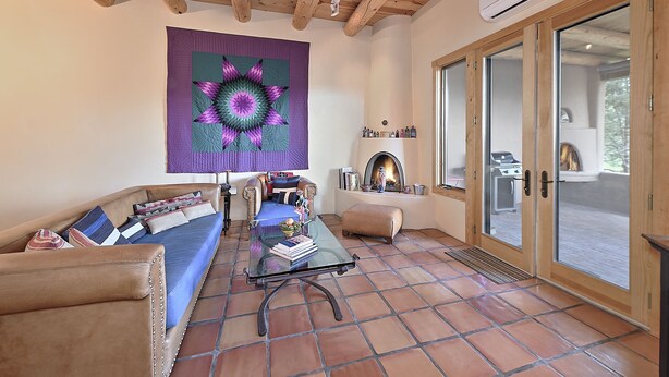 A cozy living room with a sofa, a glass coffee table, and a large quilt hanging on the wall. - 2 Bedroom, 2 Bathroom Luxury Townhome; 0.3 miles to Canyon Rd;  AC; Lovely Views (Santa Fe)