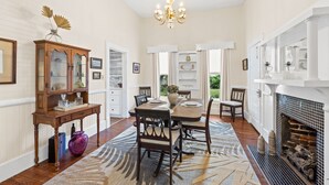 A dining room with a wooden table, chairs, a chandelier, and a fireplace. - Bay view Historic home walking to St. Joseph Bay and Downtown.  (Port St. Joe)
