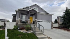 A modern two-story house with a front porch, a garage, and a well-maintained lawn.