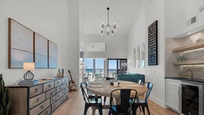 A spacious kitchen with a dining area, wooden cabinets, and a view to the outside.