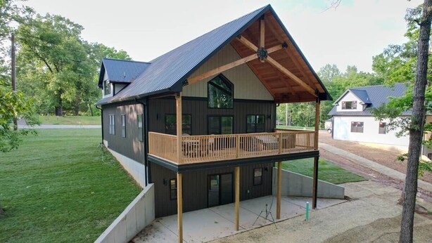 A two-story house with a balcony, a covered porch, and a large window. - Kickback Cabin at Kentucky Lake (Buchanan)