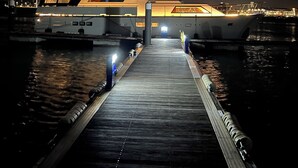 Ein Boot liegt an einem Steg, verbunden durch eine hölzerne Gangway.