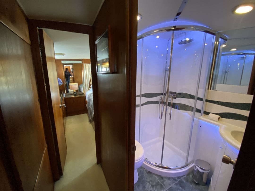 A modern bathroom with a glass-enclosed shower, a toilet, and a sink.