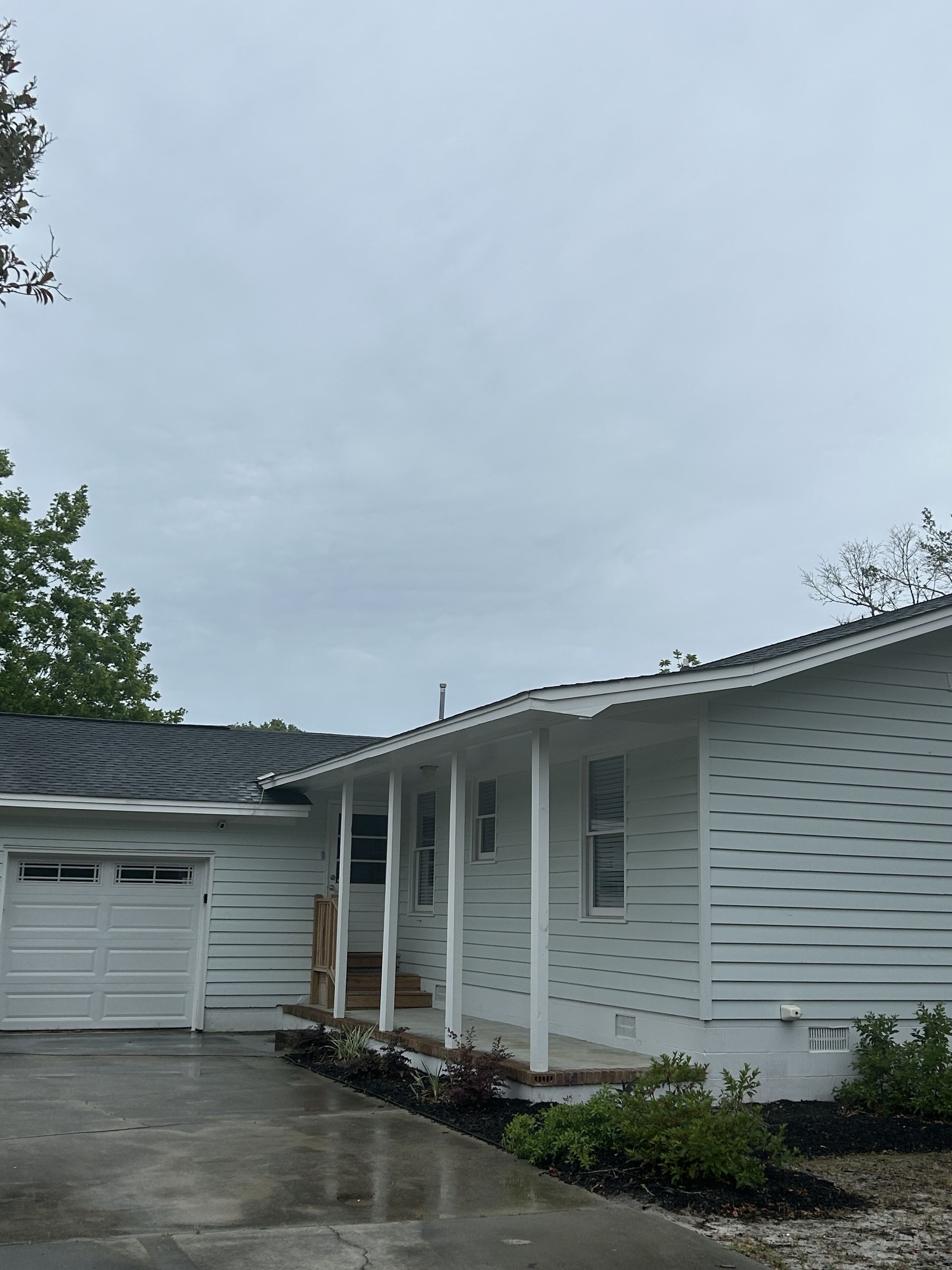 A single-story house with a covered porch, a garage, and a driveway.