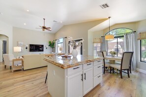 A spacious kitchen with a large island, wooden flooring, and a dining area with chairs and a table. - Near Golf & Hikes! Poolside Retreat in Phoenix (Phoenix)