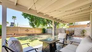 An outdoor patio with a covered seating area, a table, and a fire pit. - North Phoenix Home! Great Location + Private Patio (Phoenix)