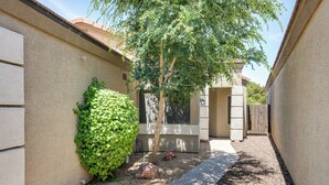 A narrow pathway leading to a building with a small tree and a rock garden. - Phoenix Home on Golf Course: Pool & Hot Tub Access (Phoenix)