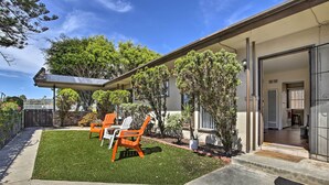 Una casa moderna con un patio, mobiliario de exterior y un césped bien cuidado.