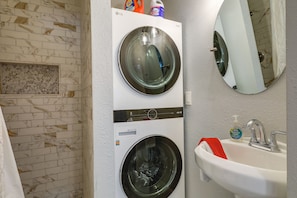 A laundry room with two stacked washing machines, a sink, and a mirror. - Tampa Home w/ Patio - 1 Mi to Busch Gardens! (Tampa)