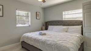 A neatly made bed with white bedding, a grey upholstered headboard, and a wooden floor. - Tampa Home w/ Patio - 1 Mi to Busch Gardens! (Tampa)