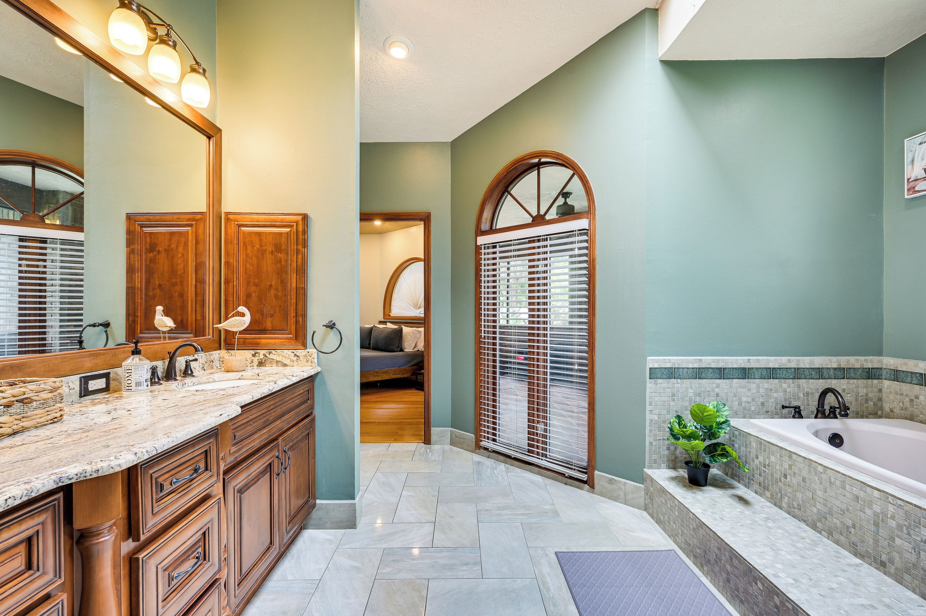 A bathroom with a large vanity, a bathtub, and a shower area.