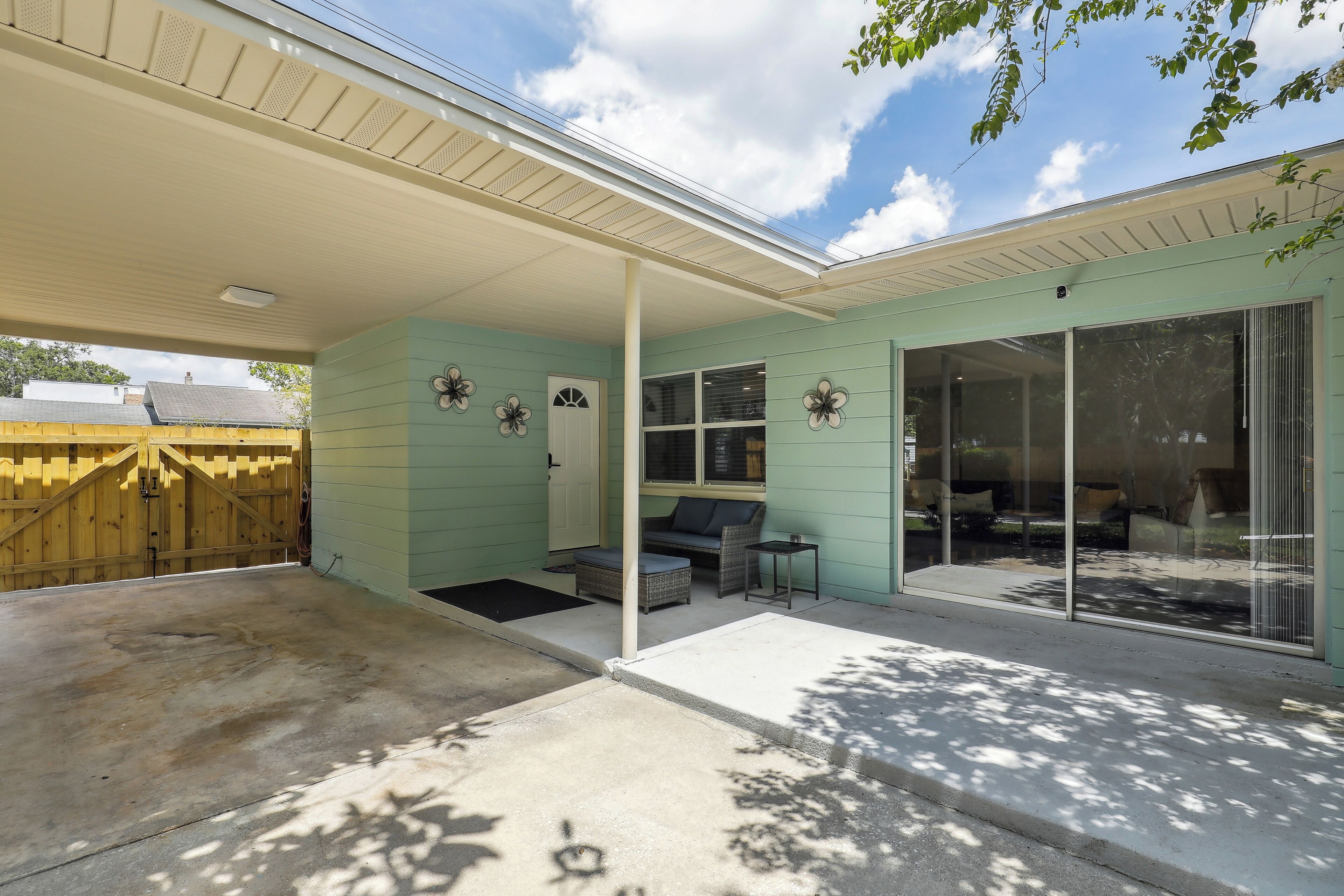 A covered patio area with a sliding glass door leading to a seating area.