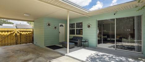 A covered patio area with a sliding glass door leading to a seating area.