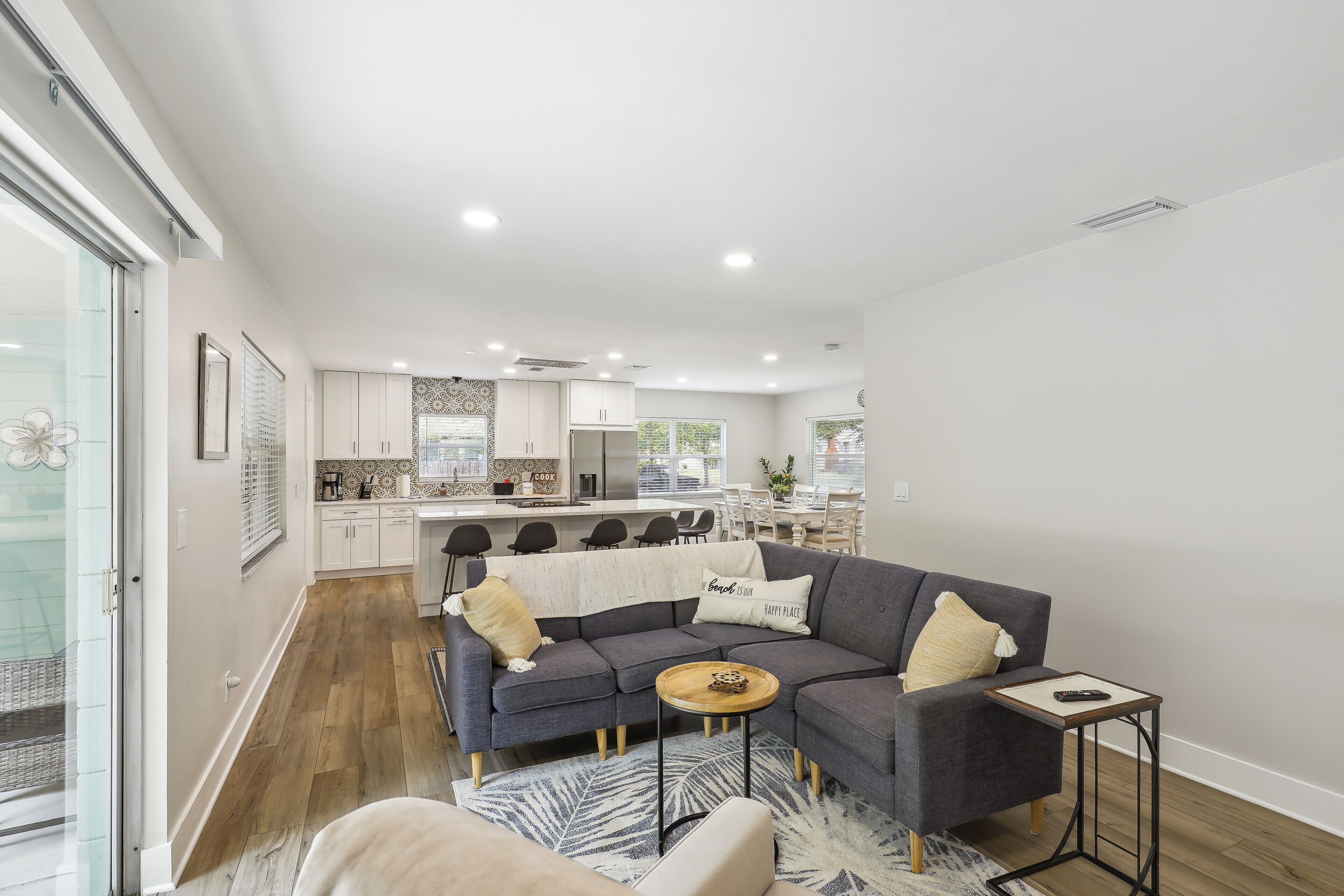 A modern living room with a grey sectional sofa, a wooden coffee table, and a small side table.