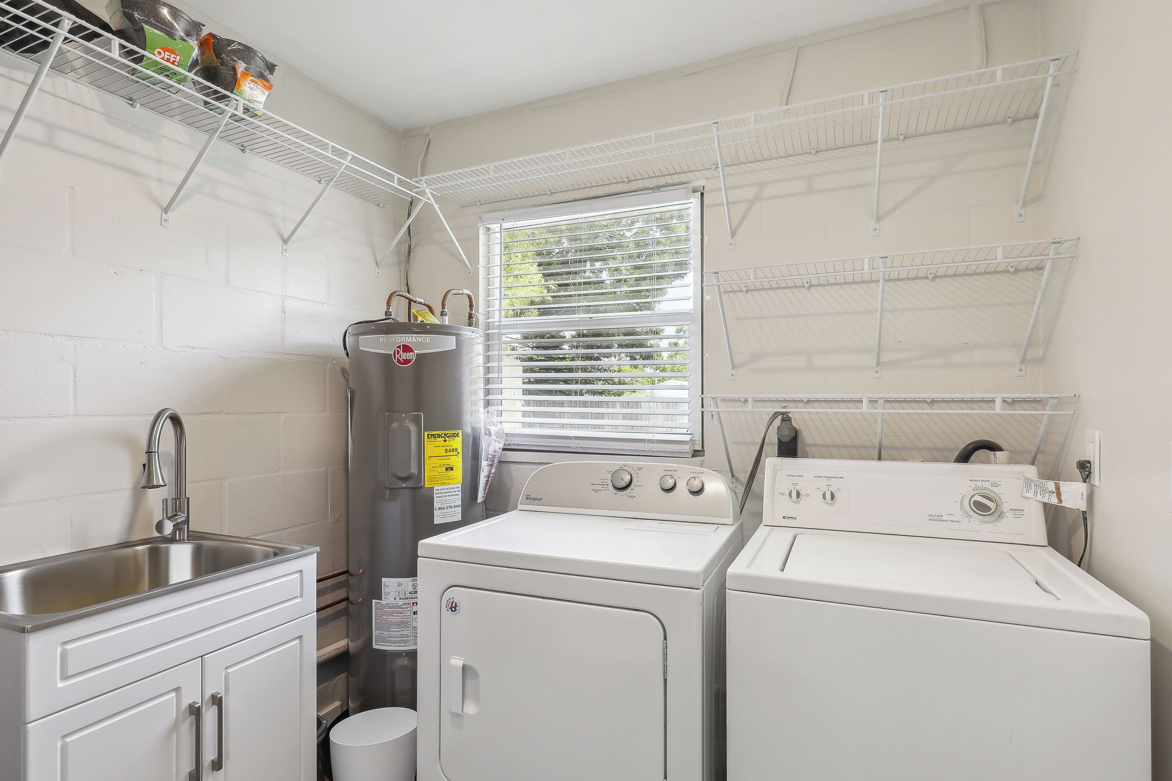 A laundry area with a washing machine, dryer, and a water heater.