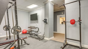 A gym with weightlifting equipment, a television, and a red exercise ball. - Downtown Jacksonville Studio w/ City Views! (Jacksonville)