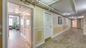 A hallway with white doors, beige walls, and a patterned floor. - Downtown Jacksonville Studio w/ City Views! (Jacksonville)