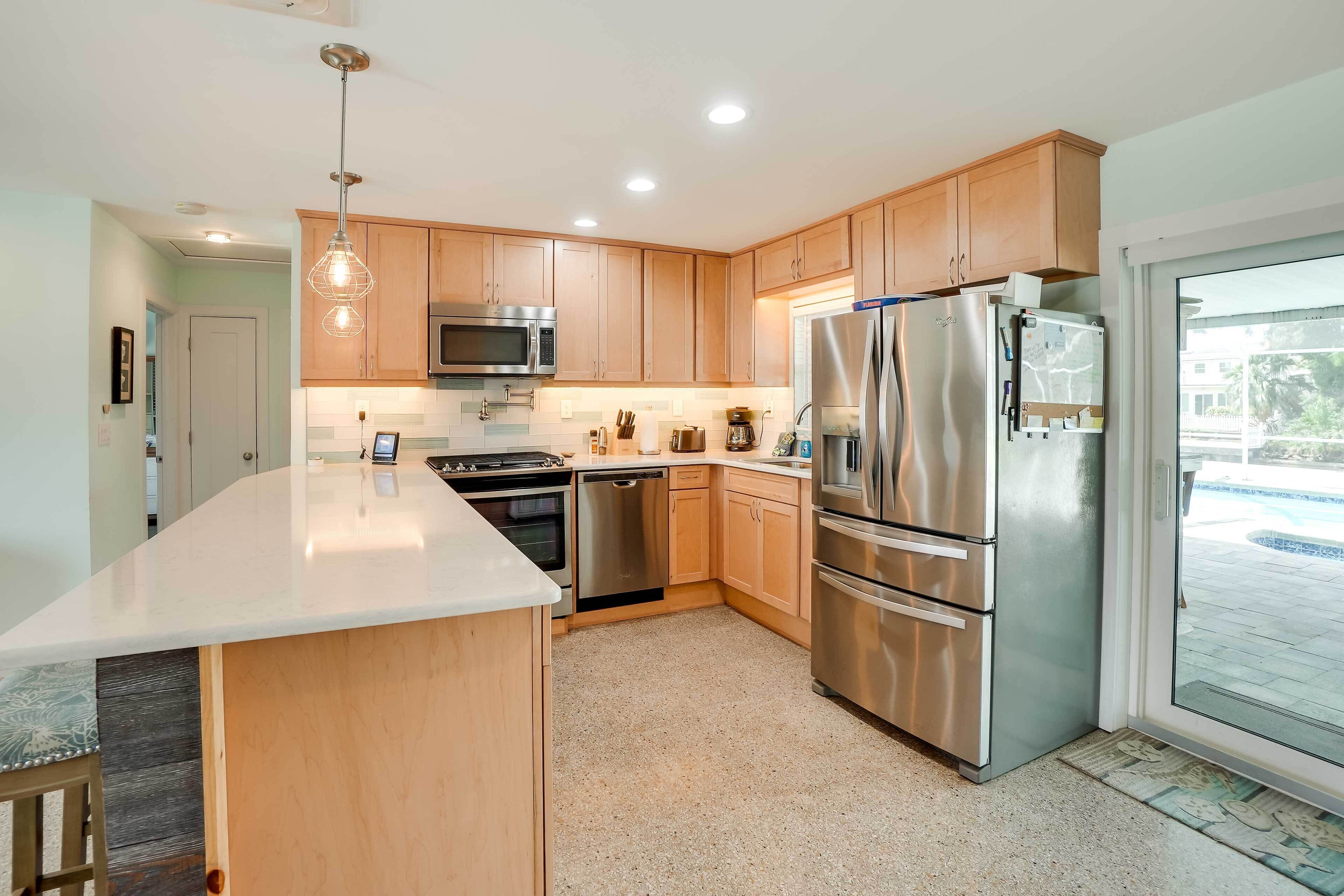 A modern kitchen with wooden cabinets, stainless steel appliances, and a large island.