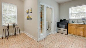 A kitchen with a stove, oven, and a dining area with stools. - Jacksonville Vacation Rental ~ 7 Mi to Downtown! (Jacksonville)