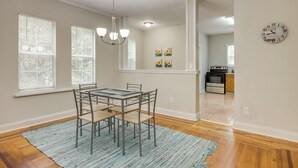 A dining area with a table and chairs, a chandelier, and artwork on the wall. - Jacksonville Vacation Rental ~ 7 Mi to Downtown! (Jacksonville)