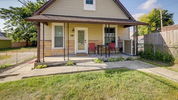 A single-story house with a front porch, a small patio area, and a fenced backyard. - Indianapolis Home w/ Porch - Close to Mile Square! (Indianapolis)