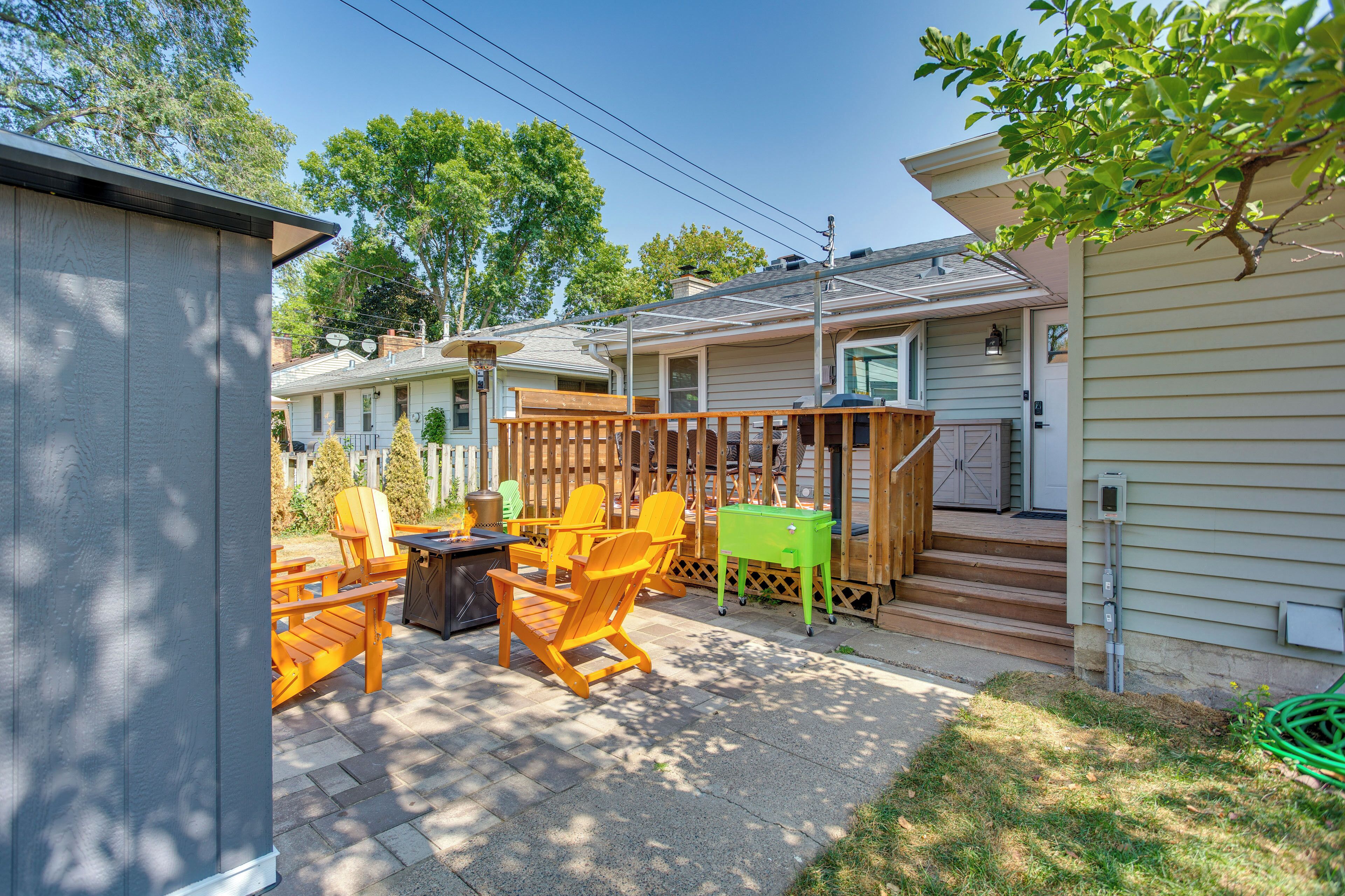A patio with outdoor furniture, a wooden deck, and a house in the background.