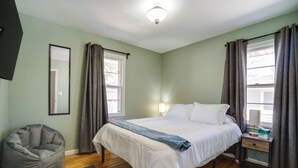 Ein Schlafzimmer mit Bett, Nachttisch, Lampe und einem Sitzsack.
