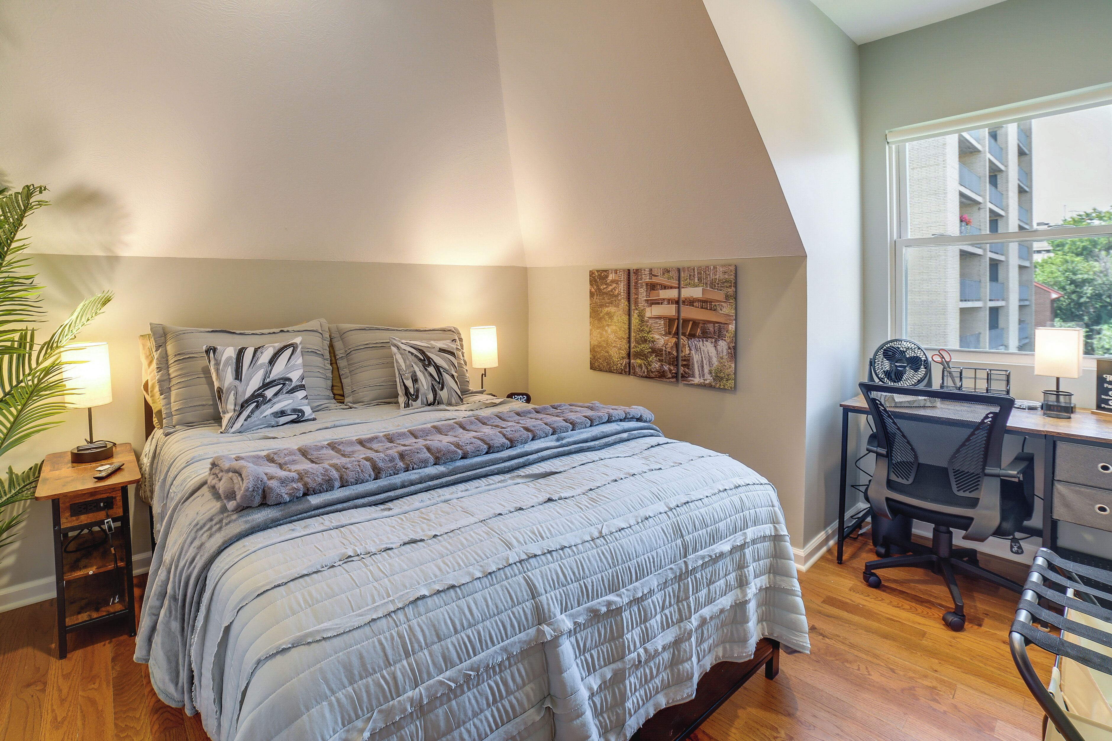 A bedroom with a large bed, a desk, and a chair.