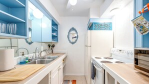A kitchen with white cabinets, a wooden countertop, a stove, and a sink. - Dallas Vacation Rental Condo w/ Community Pool! (Dallas)
