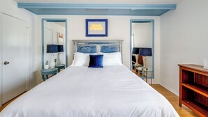 A neatly arranged hotel room with a large bed, a bedside table, a lamp, and a framed picture on the wall. - Dallas Vacation Rental Condo w/ Community Pool! (Dallas)
