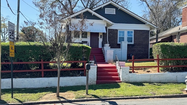 A residential house with a red front door, a brick exterior, and a white trim. There is a mailbox on the front steps and a red fence surrounding the property. - Atlanta Vacation Rental ~ 3 Mi to Downtown! (Atlanta)