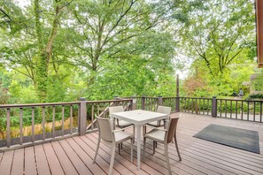 A wooden deck with a table and chairs, surrounded by a wooden fence and lush greenery. - Patio & Outdoor Dining! ATL Stay Near Intl Soccer (Atlanta)