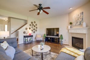Relax in this inviting living space with a comfortable sofa, flat-screen TV, and cozy fireplace.