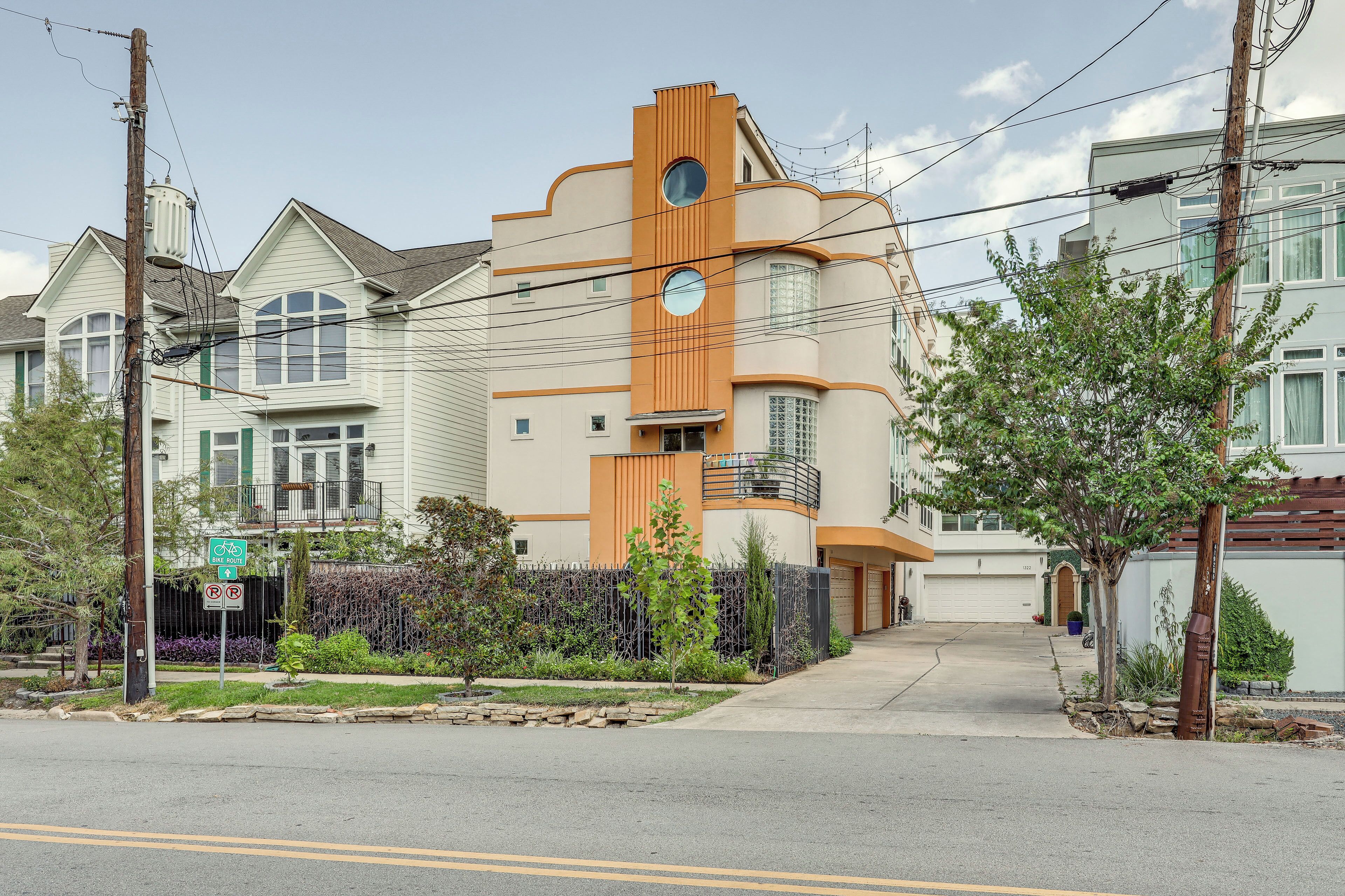 A residential building with a unique architectural design, featuring a prominent orange section and multiple windows.