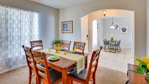 A dining area with a wooden table, chairs, and a chandelier. - Florida Retreat w/ Pool, Hot Tub & Near Disney! (Davenport)